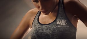 A woman exercising wearing a Glanbia sports top