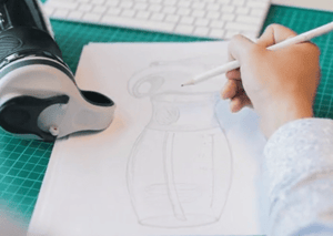 A Novelli industrial designer drawing a sketch of a new bottle design