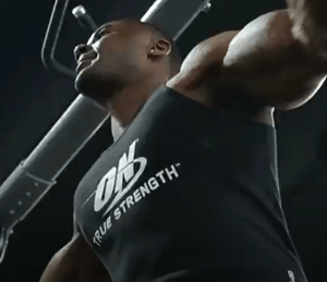 Close up of a man working out wearing an Optimum Nutrition black singlet top