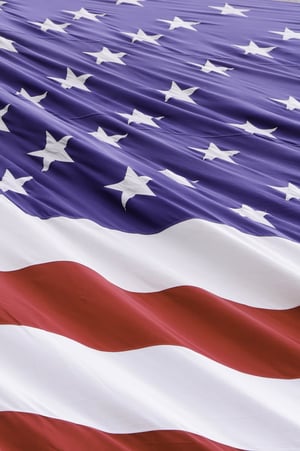 Vertical section of windblown American flag with undulating stripes and diagonal ripples like schisms among stars